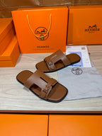 Hermes brown leather sandals with wide straps and metal buckle, two shoes side by side
