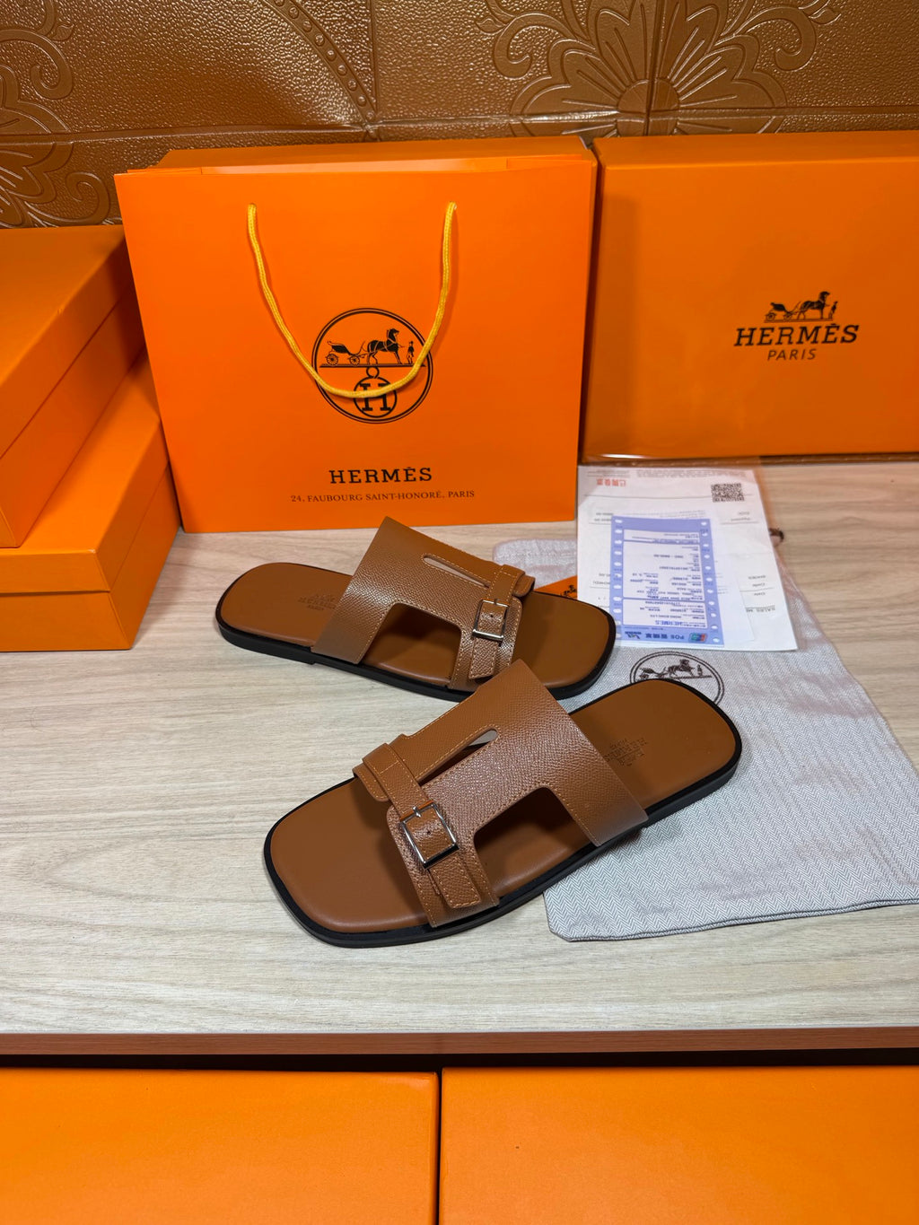 Hermes brown leather sandals with double strap and metal buckle, close side angle