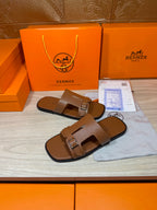 Hermes brown leather sandals with double strap and metal buckle, close side angle