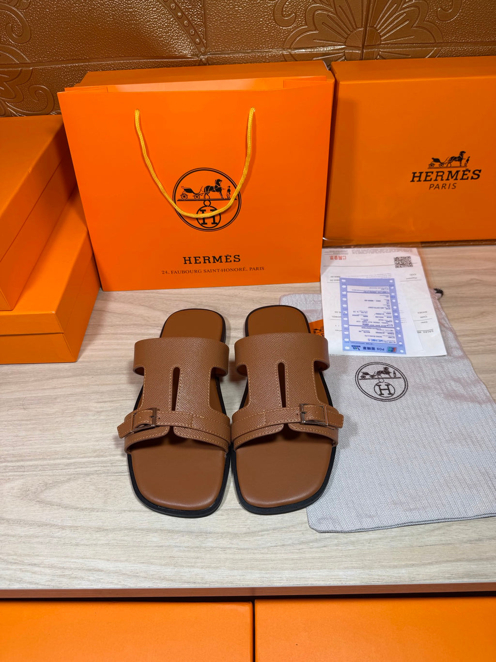 Hermes brown leather sandals with double strap and metal buckle, shown front pair