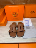 Hermes brown leather sandals with double strap and metal buckle, shown front pair