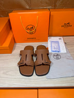 Hermes brown leather sandals with double strap and metal buckle, shown front pair
