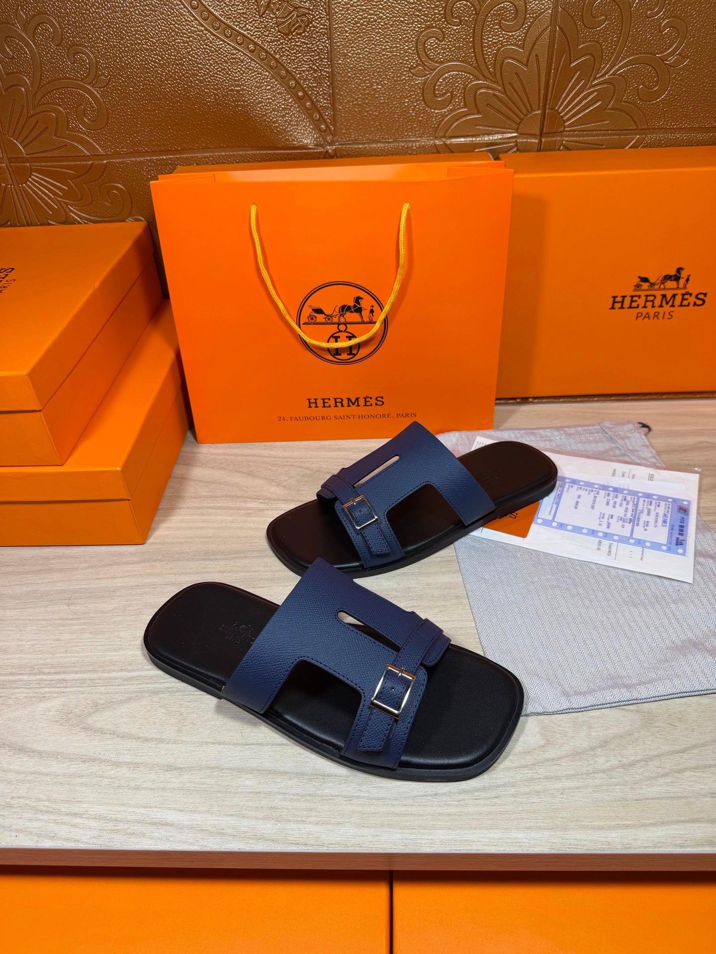 Navy slide sandals with double strap design and square buckle hardware on footbed