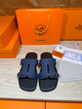 Navy slide sandals with two wide straps and rectangular buckle on dark footbeds
