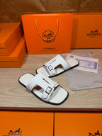White leather slide sandals with square buckle hardware on two straps