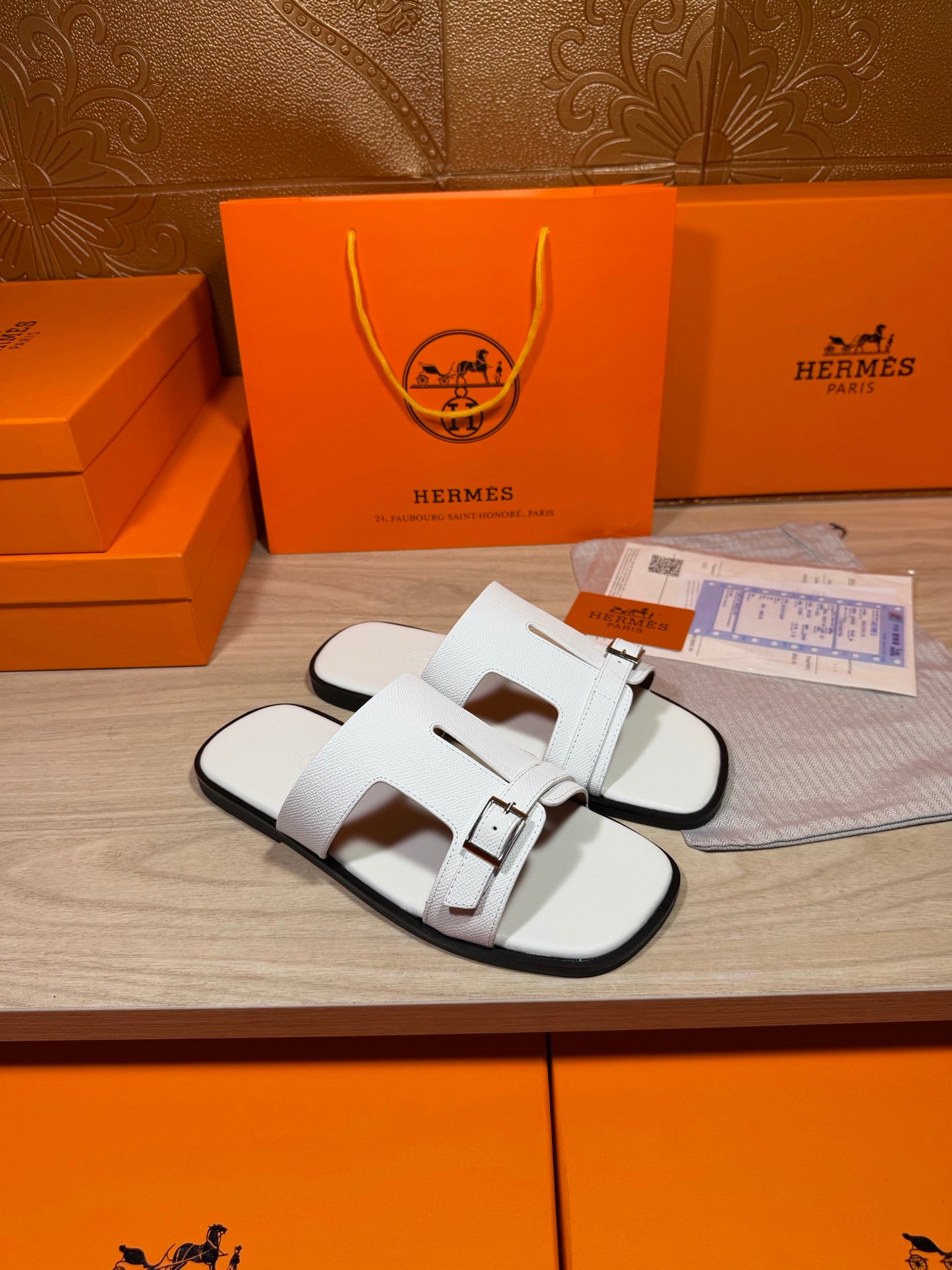White leather slide sandals with twin straps and metal buckles, side view