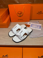 White leather slide sandals with two buckled straps and open toe profile