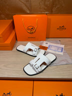 White leather slide sandals with adjustable buckles and open-toe design