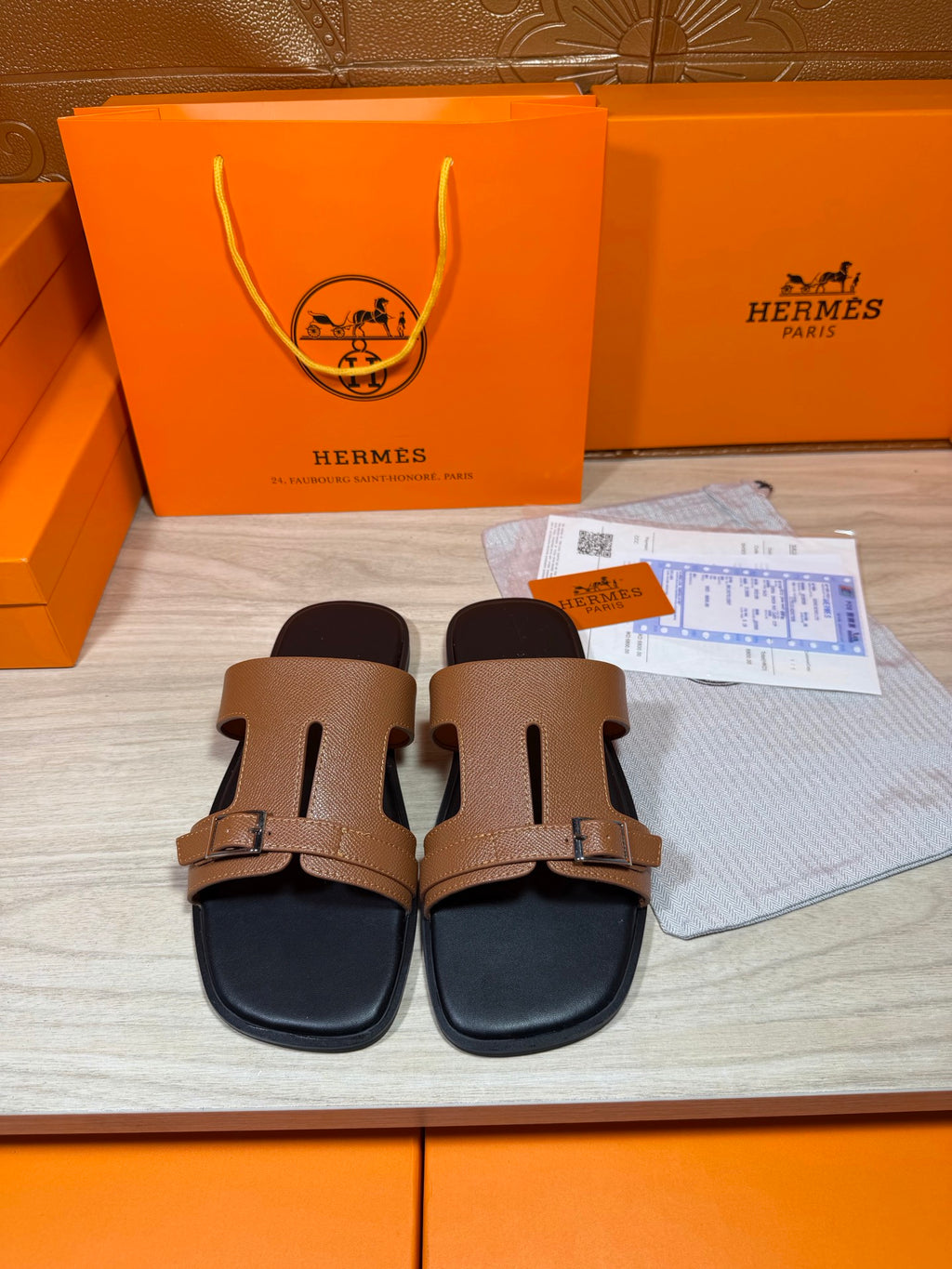 Tan double-strap leather slide sandals with gold-tone buckles and black footbed
