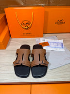 Tan double-strap leather slide sandals with gold-tone buckles and black footbed