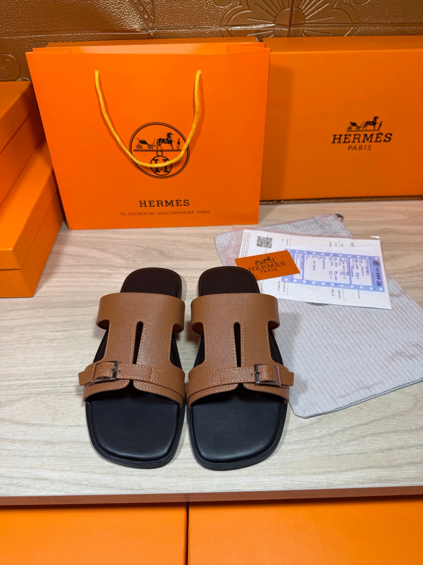 Tan double-strap leather slide sandals with gold-tone buckles and black footbed