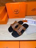 Tan leather slide sandals with gold-tone buckle strap and black footbed, double-strap