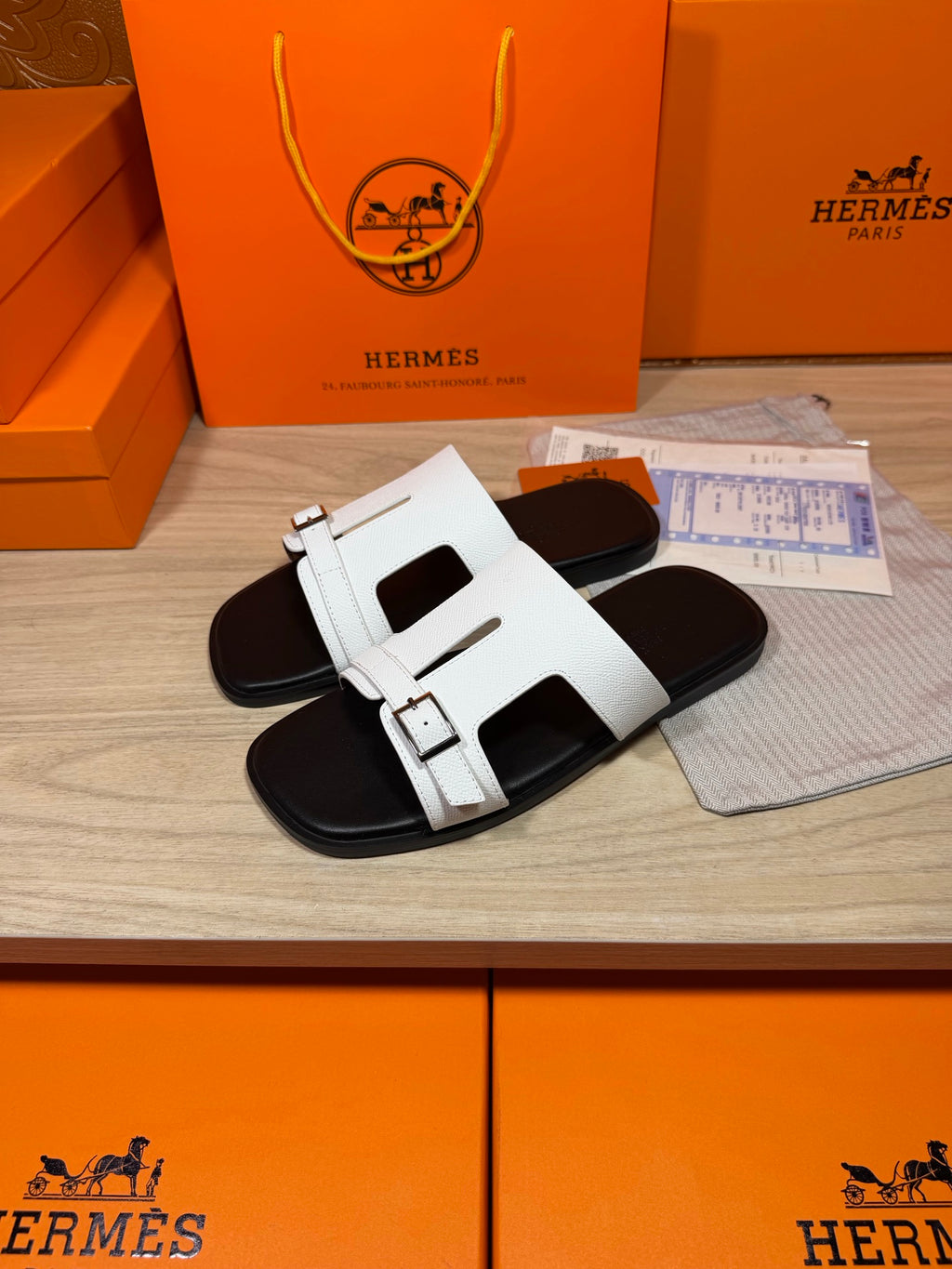 White slide sandals, side view, with double straps and silver buckles