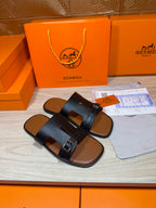 Hermes dark blue slide sandals with wide cross straps and rectangular buckle accents