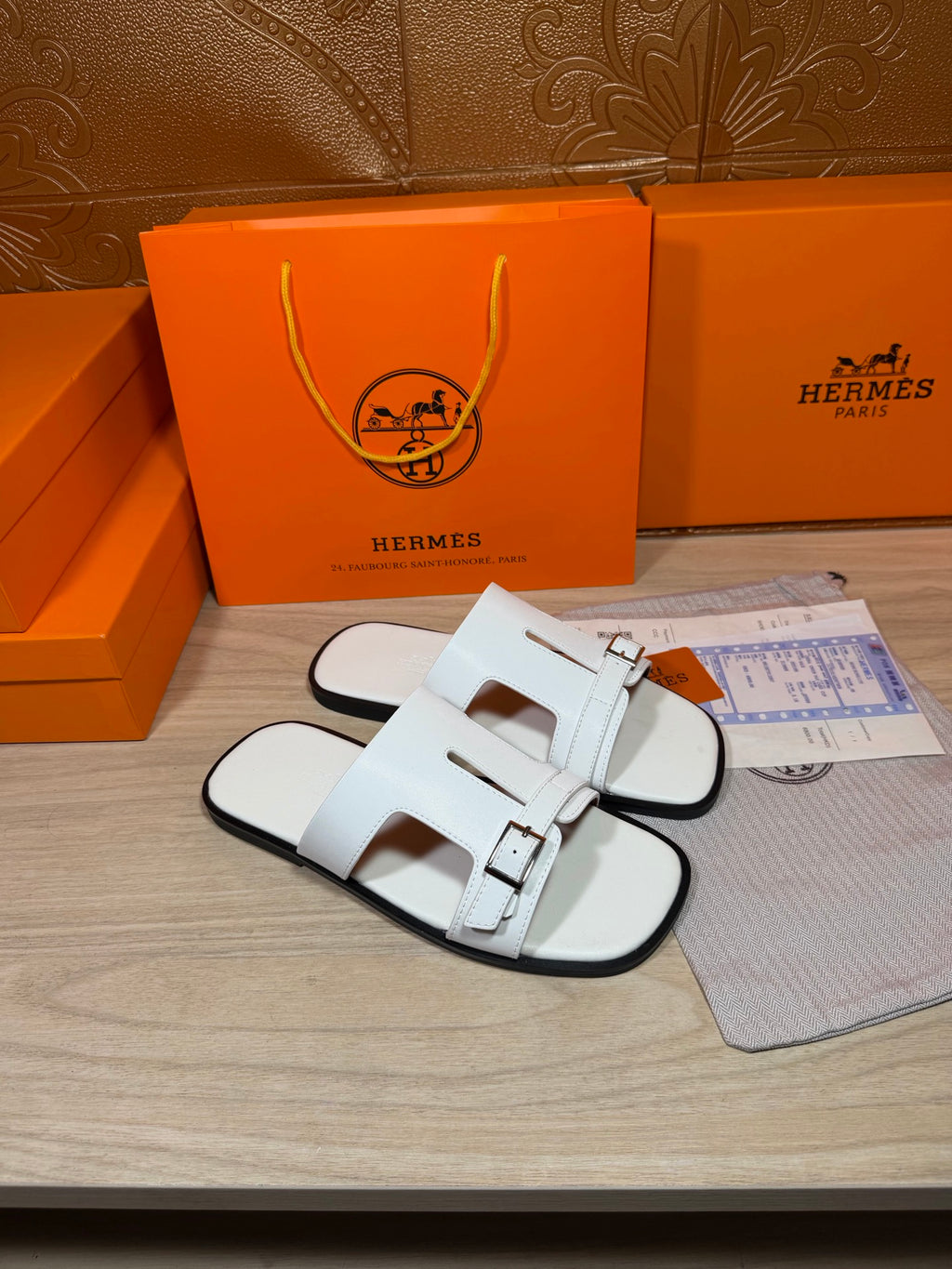 White slide sandals showing front strap detail with silver-tone buckle