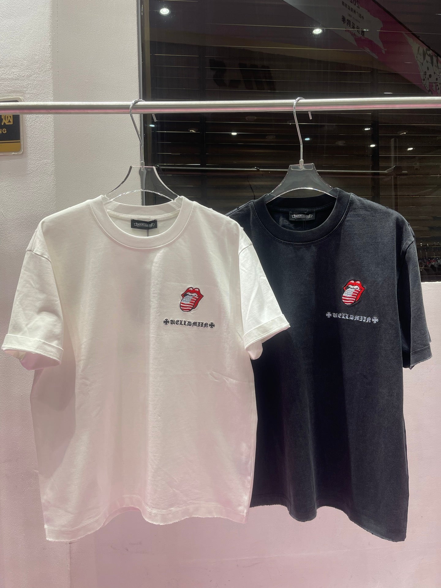 Two short-sleeve crewneck graphic T-shirts: white and dark charcoal with red logo