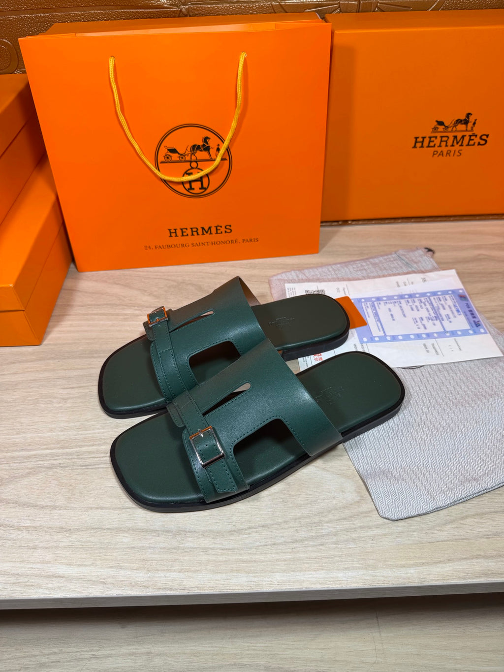 Hermes teal-green slide sandals with double buckles and wide strap details, open toe