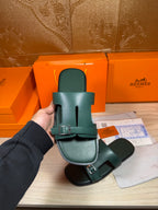 Hermes teal-green slide sandals close-up with adjustable strap buckle and open toe