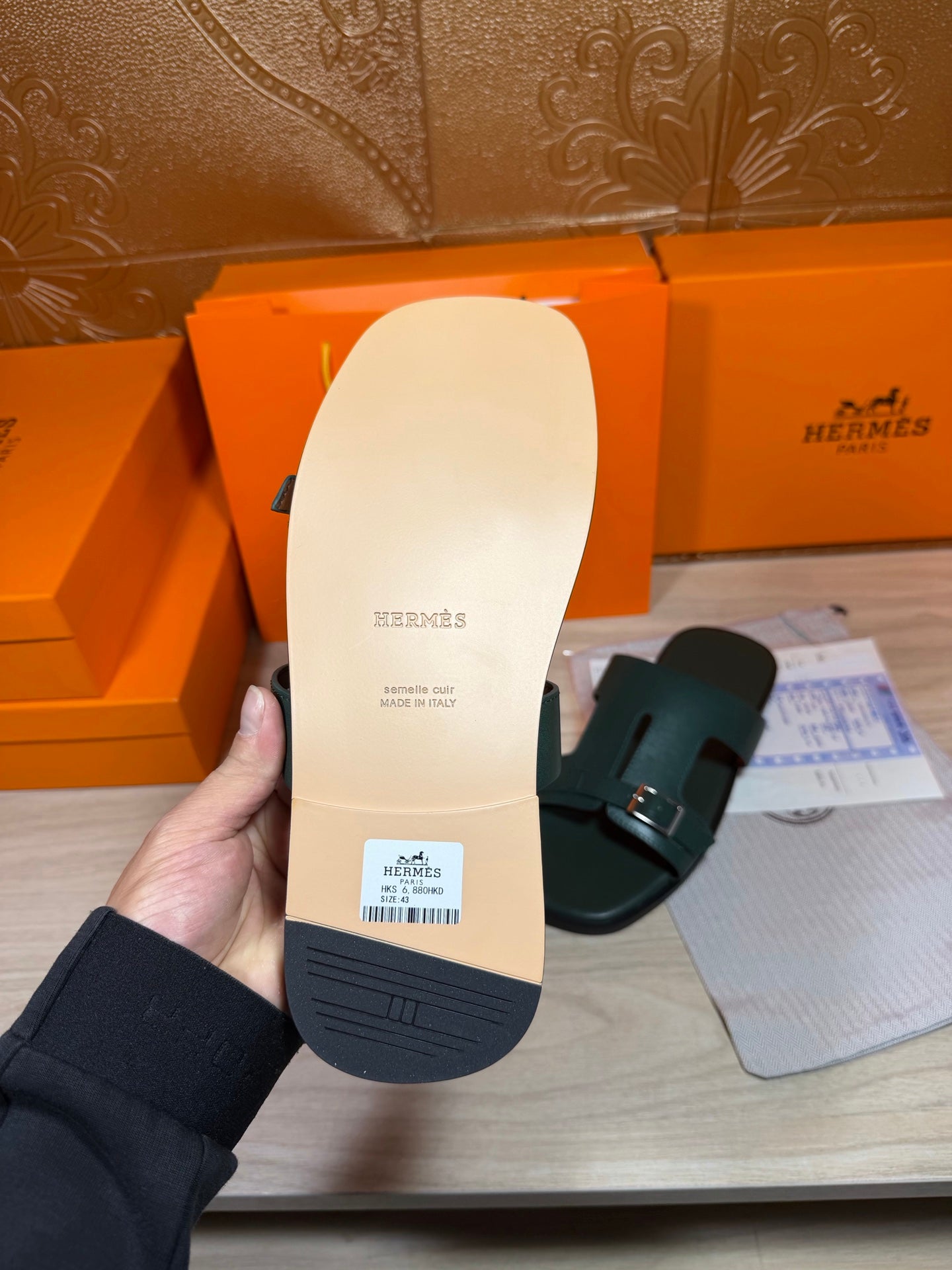 Hermes teal-green slide sandal outsole view with dark tread and stamped logo
