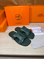 Hermes teal-green leather slide sandals with adjustable buckle straps and textured sole