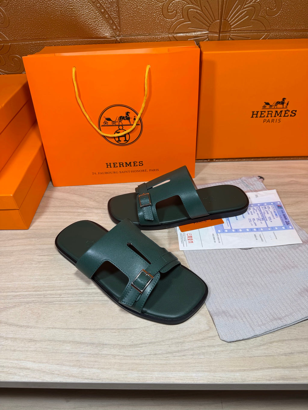 Hermes teal-green leather slide sandals showing top straps and adjustable buckle closure