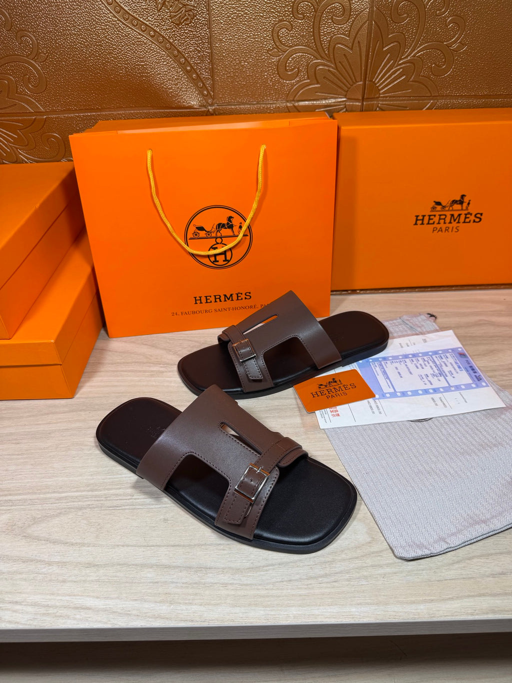 Brown leather slide sandals with double straps and metal buckle detail