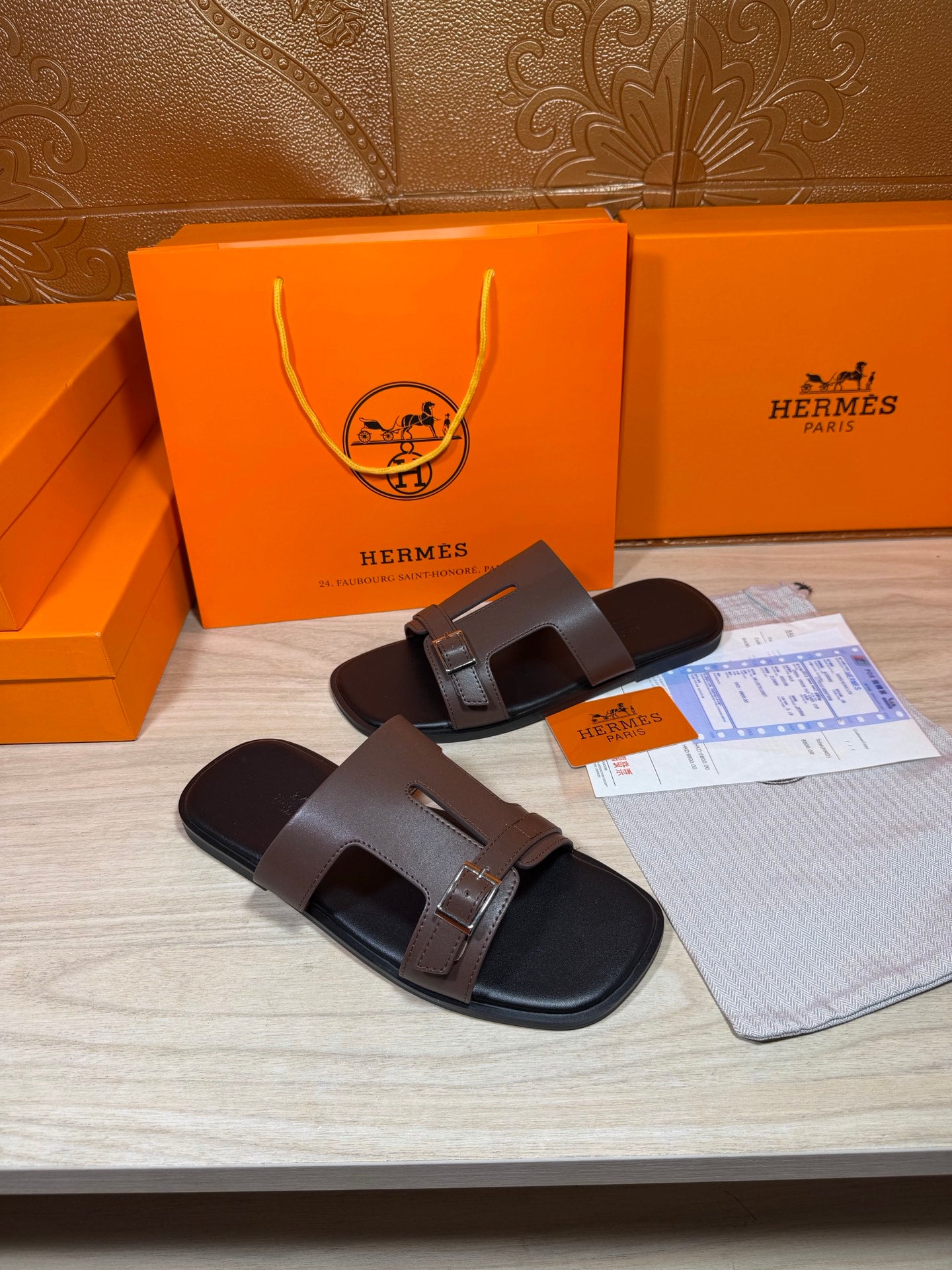 Brown leather slide sandals with double straps and metal buckle detail