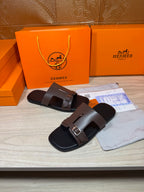 Brown leather slide sandals with two adjustable straps and silver buckle hardware