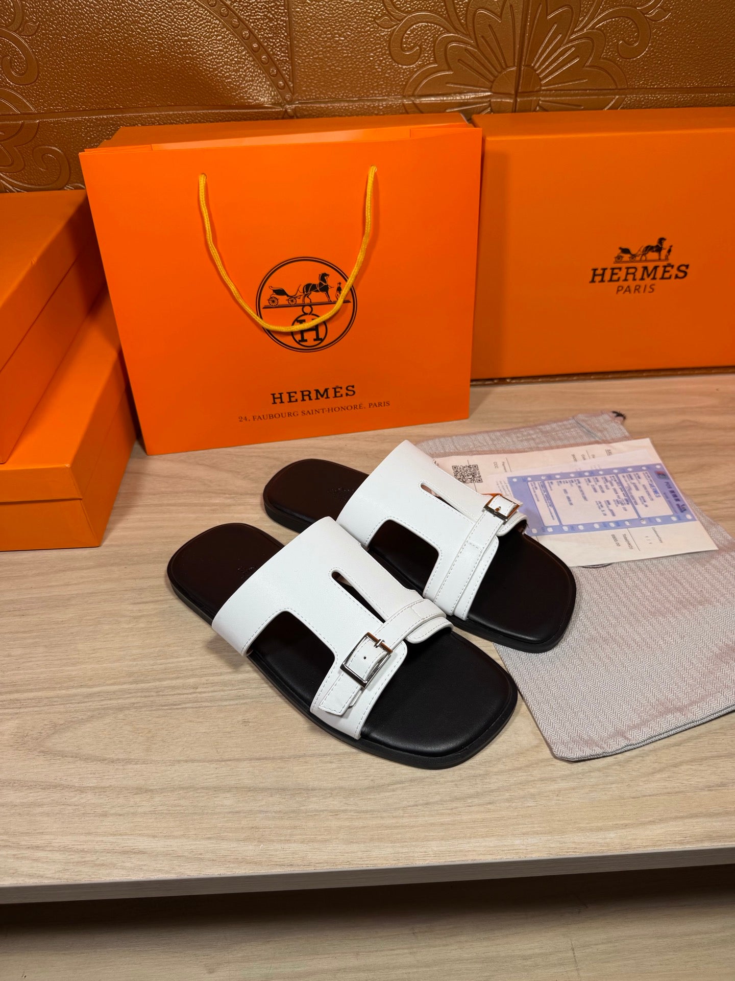 White Hermes slide sandals with two buckled straps and black footbed