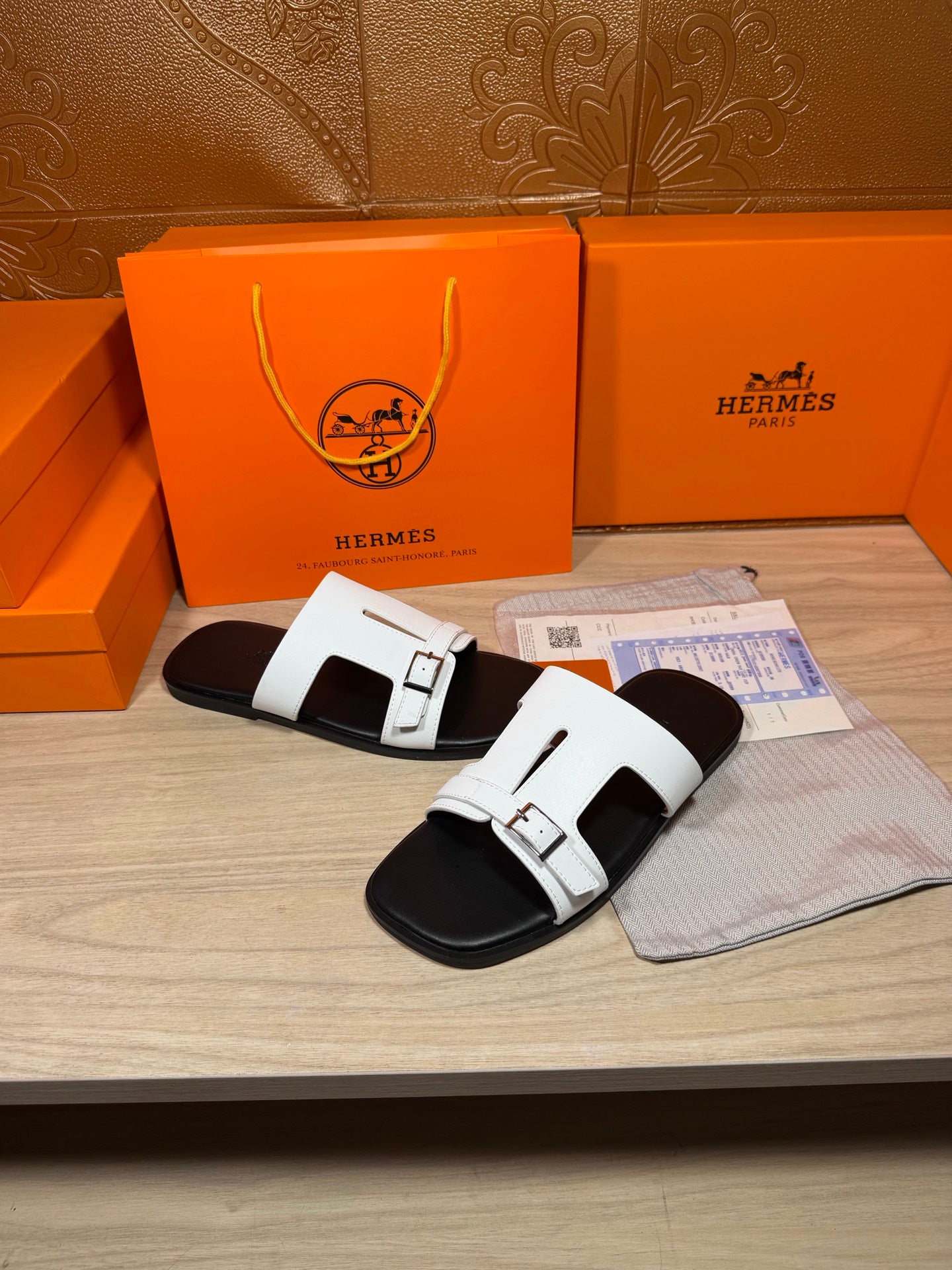 White Hermes slide sandals with adjustable buckles and black outsole