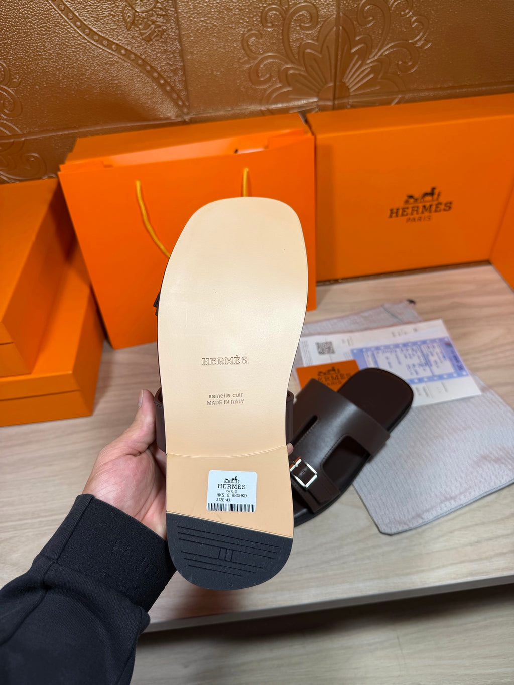 Cream outsole of a leather slide sandal with buckle-strap upper