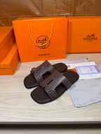 Brown leather slide sandals with double buckled straps, side view