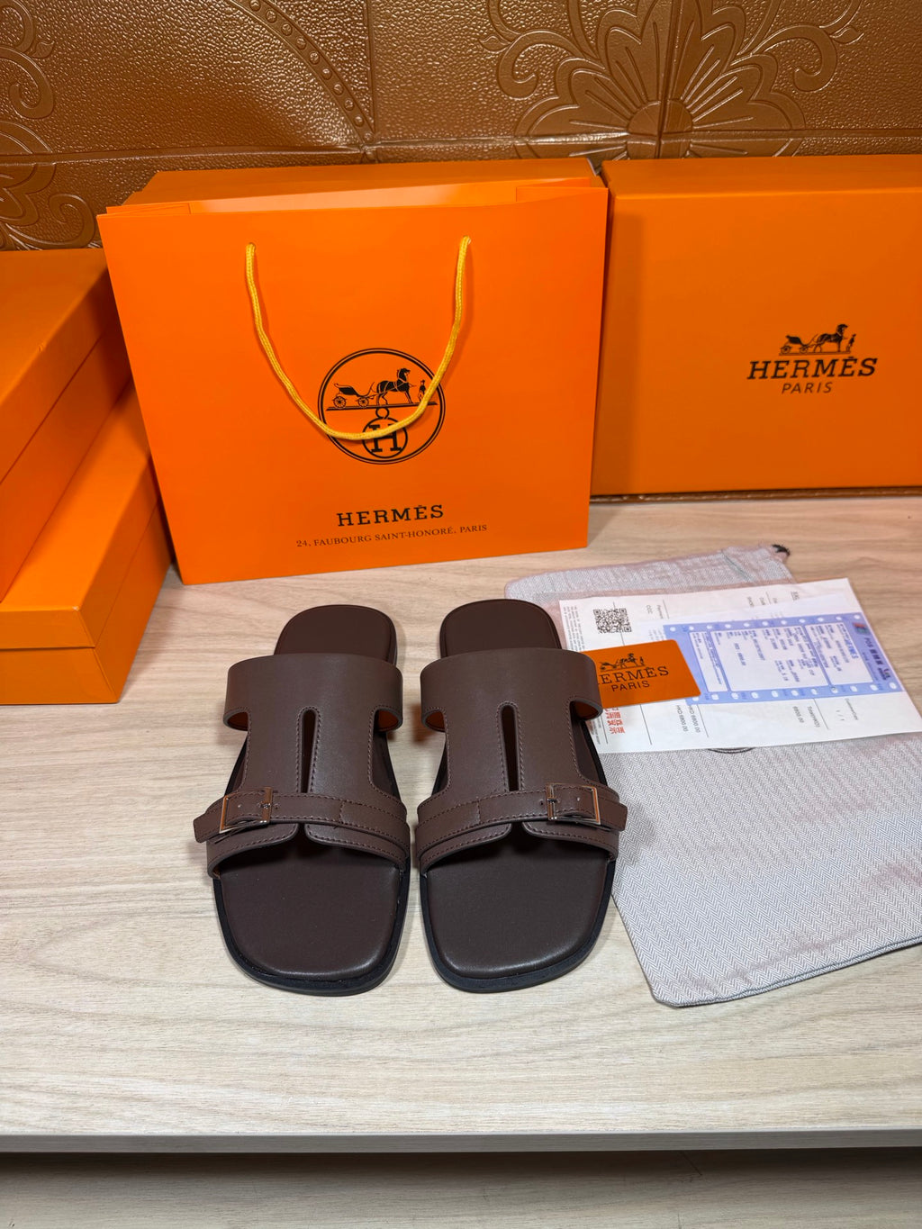 Brown leather slide sandals with two buckled straps and open toe