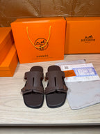 Brown leather slide sandals with two buckled straps and open toe