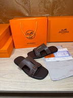Brown leather slide sandals with two buckled straps and squared toe opening