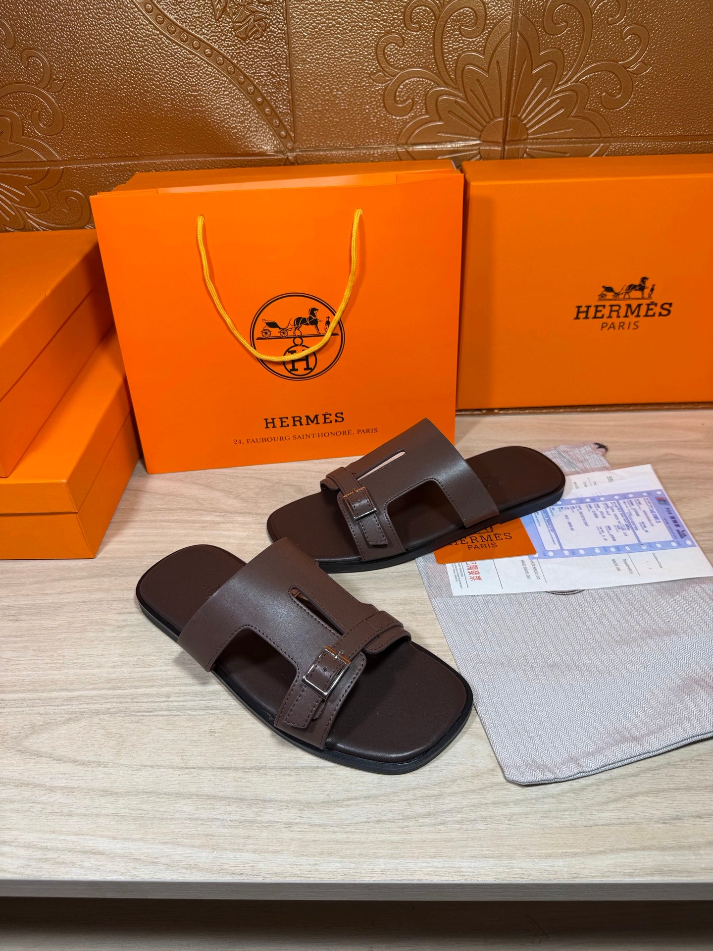 Brown leather slide sandals with two buckled straps and squared toe opening