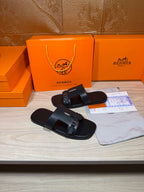Black slide sandals with two straps and square metal buckles