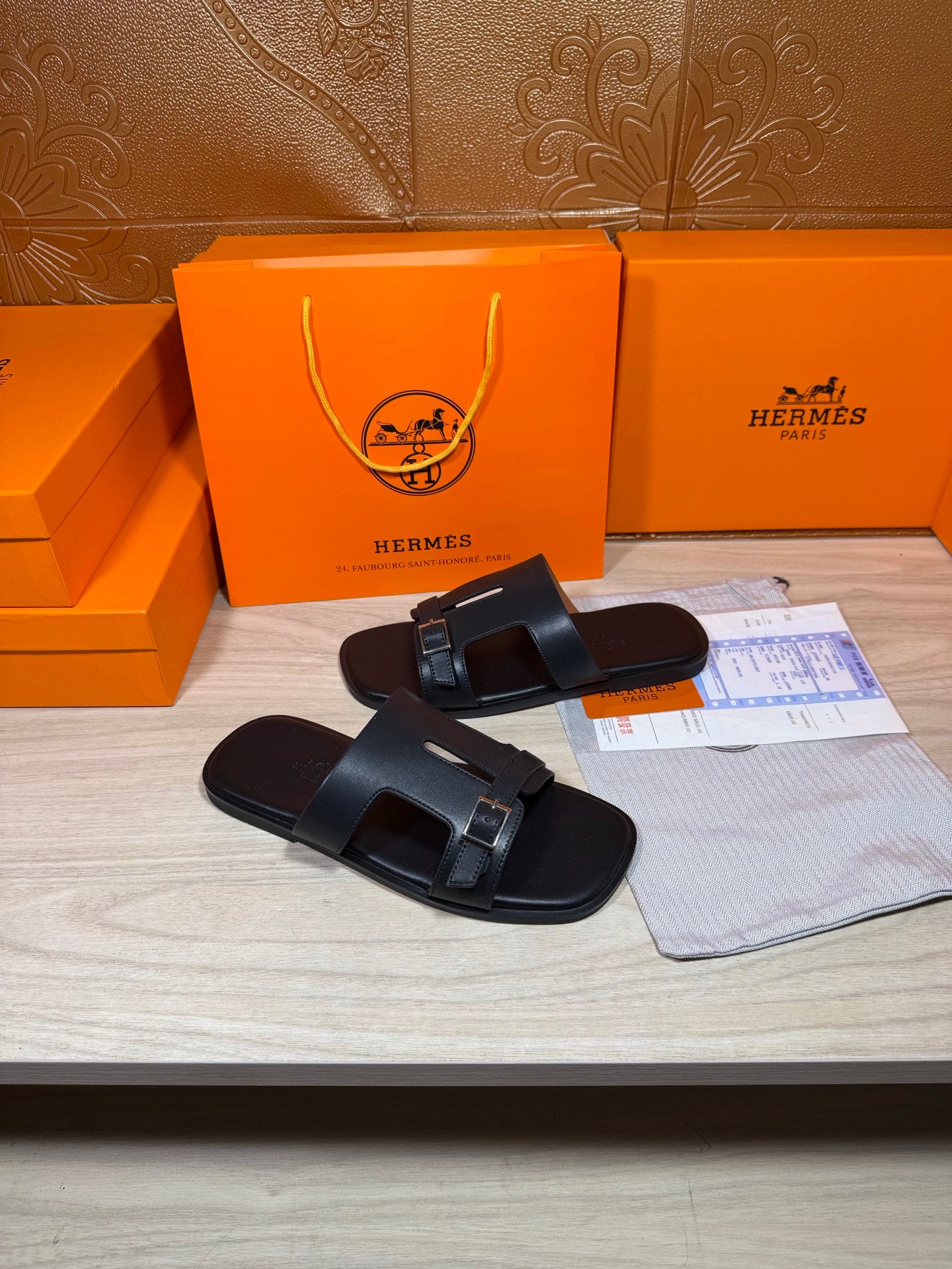 Black slide sandals with two straps and square metal buckles