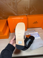 Black sandal sole and footbed shown in hand, with side strap visible