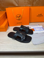 Black slide sandals with double straps and metal buckle accents