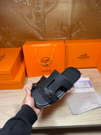 Black slide sandals held together, featuring two adjustable buckles