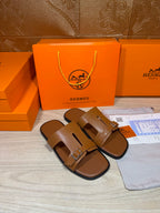 Hermes tan leather sandals with single-bar buckle strap design, side view.