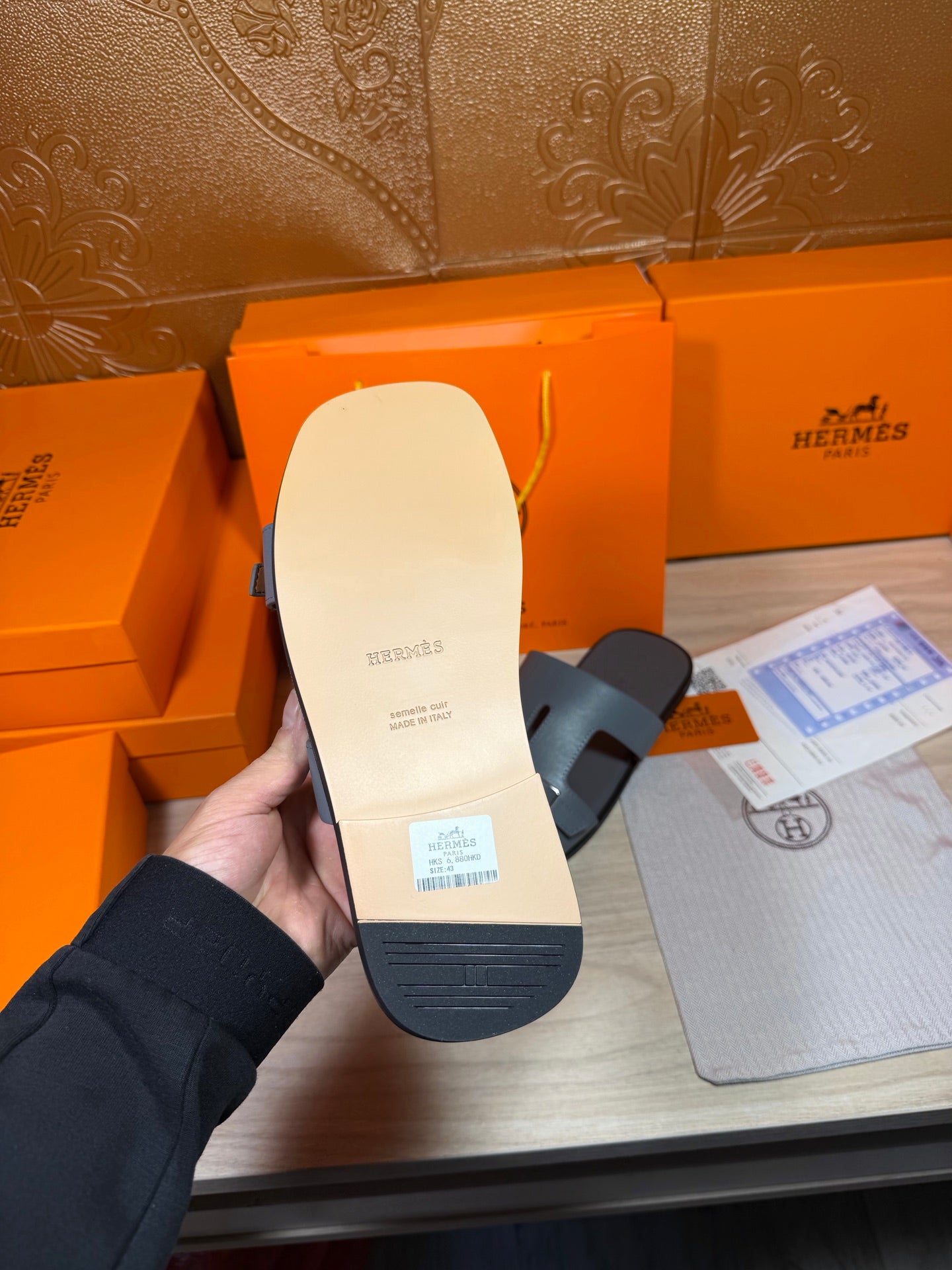 Hermes sandals heel view: light footbed with branding and textured sole underside.