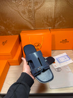 Hermes blue slide sandal with wide strap, silver buckle, and cutout footbed