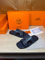 Hermes blue slide sandals with front buckle and cushioned footbed, open toe