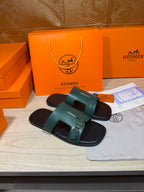 Pair of Hermes sandals with teal single-band straps and black footbed, buckle closure