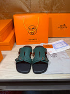 Hermes sandals with teal slide straps and black base, adjustable buckle detail
