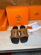 Tan and black leather sandals with two buckle straps, shown as a pair