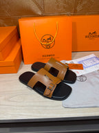 Tan and black leather slide sandals with two adjustable buckle straps