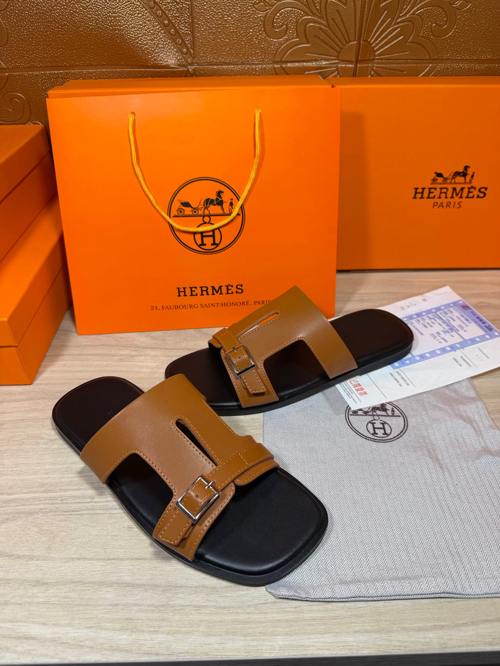 Tan and black leather slide sandals with double buckle front strap
